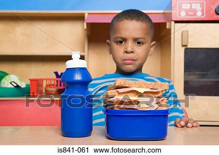 Boy looking at lunch box View Large Photo Image Stock Image - Boy looking at lunch box. Fotosearch