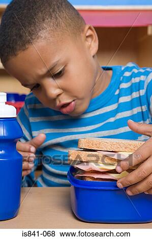 Boy looking at lunch box View Large Photo Image Stock Photo - Boy looking at lunch box. Fotosearch