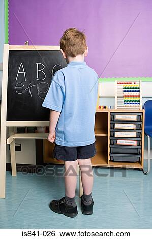Boy writing on blackboard View Large Photo Image Stock Photograph - Boy writing on blackboard. Fotosearch