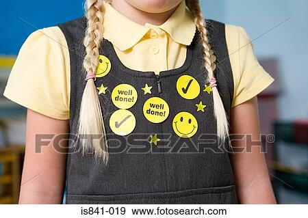 Stock Photo - Stickers on a girls pinafore. Fotosearch