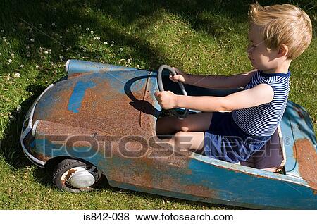 Boy in an old toy car View Large Photo Image Stock Photo - Boy in an old toy car. Fotosearch