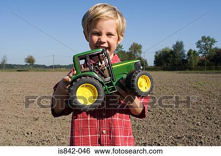 Boy with a toy tractor View Large Photo Image Stock Photograph - Boy with a toy tractor. Fotosearch