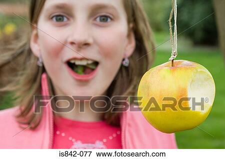 Girl and apple on a string View Large Photo Image Stock Photo - Girl and apple on a string. Fotosearch