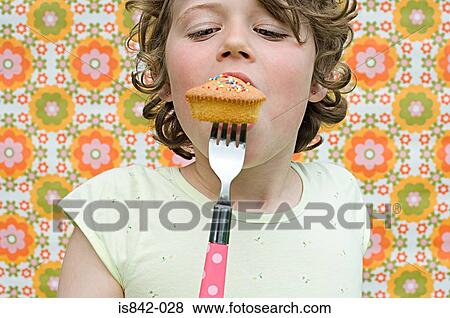 Girl eating cupcake with fork View Large Photo Image Stock Photo - Girl eating cupcake with fork. Fotosearch