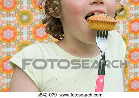 Girl eating cupcake with fork View Large Photo Image Stock Photo - Girl eating cupcake with fork. Fotosearch
