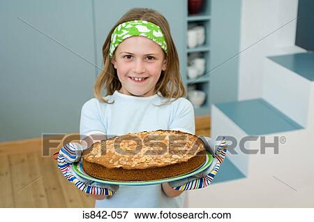 Girl holding an almond cake View Large Photo Image Stock Photo - Girl holding an almond cake. Fotosearch
