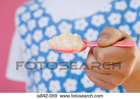 Girl holding spoon of dessert View Large Photo Image Stock Photo - Girl holding spoon of dessert. Fotosearch