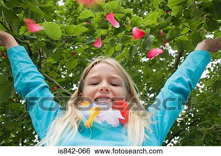 Girl throwing petals in the air View Large Photo Image Stock Photograph - Girl throwing petals in the air. Fotosearch