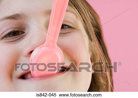 Stock Photography - Girl with plastic spoon in her mouth. Fotosearch