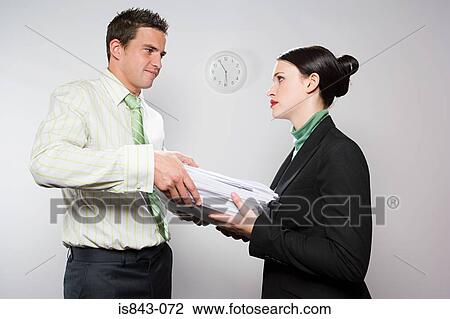 Businessman handing colleague paperwork View Large Photo Image Stock Image - Businessman handing colleague paperwork. Fotosearch