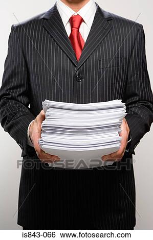 Businessman holding paperwork View Large Photo Image Stock Photograph - Businessman holding paperwork. Fotosearch