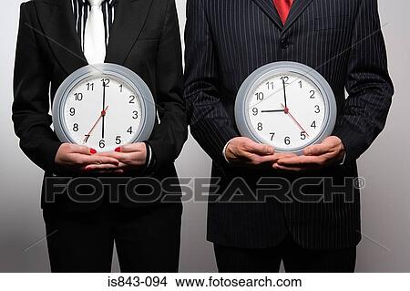 Picture - Businesspeople holding clocks. Fotosearch