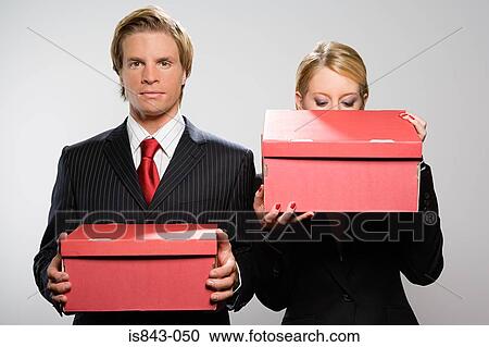 Two colleagues holding boxes View Large Photo Image Stock Image - Two colleagues holding boxes. Fotosearch