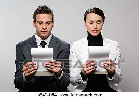 Picture - Two colleagues looking at notebook. Fotosearch