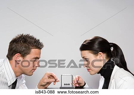 Two colleagues playing with a newtons cradle View Large Photo Image Stock Photo - Two colleagues playing with a newtons cradle. Fotosearch