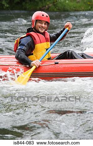 Stock Image - Man white water rafting. Fotosearch