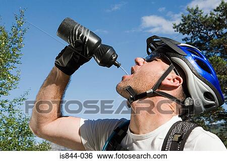 Stock Photograph - Mountain biker drinking from bottle. Fotosearch