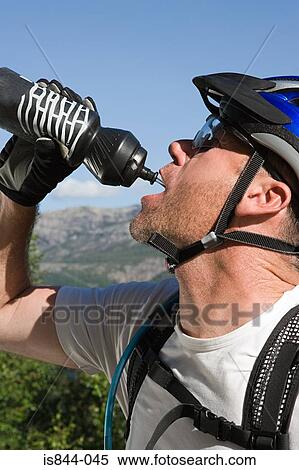 Stock Photography - Mountain biker drinking from bottle. Fotosearch