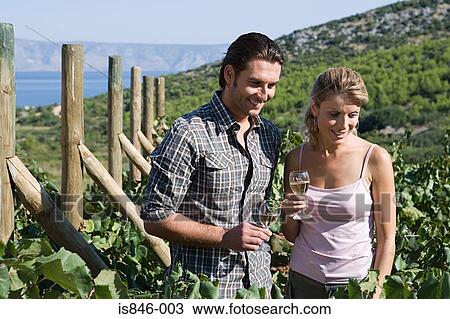 Stock Image - Couple looking at vines. Fotosearch