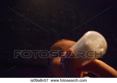 Baby girl feeding from bottle in darkness View Large Photo Image Stock Photo - Baby girl feeding from bottle in darkness. Fotosearch