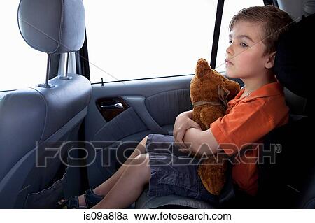 Boy in child safety seat in car holding teddy bear View Large Photo Image Stock Image - Boy in child safety seat in car holding teddy bear. Fotosearch