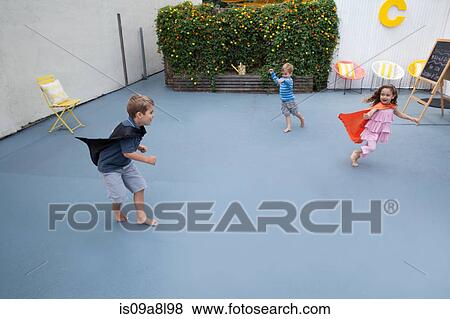 Boys and girl wearing superhero capes playing in back yard View Large Photo Image Stock Photo - Boys and girl wearing superhero capes playing in back yard. Fotosearch