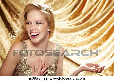 Candid portrait of young woman in front of gold curtain View Large Photo Image Stock Photo - Candid portrait of young woman in front of gold curtain. Fotosearch