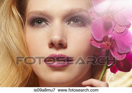 Close up of young woman holding orchid stem View Large Photo Image Stock Photo - Close up of young woman holding orchid stem. Fotosearch