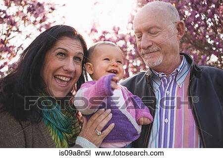 Stock Image - Close up portrait of baby girl and grandparents. Fotosearch