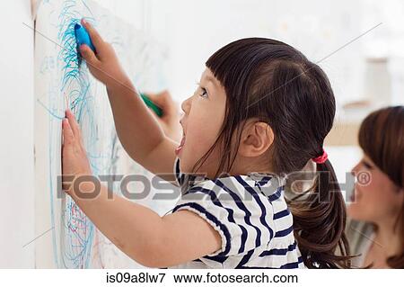 Stock Photo - Close up portrait of female toddler having fun drawing. Fotosearch