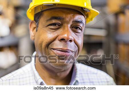 Close up portrait of man in stockroom wearing hard hat View Large Photo Image Stock Photography - Close up portrait of man in stockroom wearing hard hat. Fotosearch