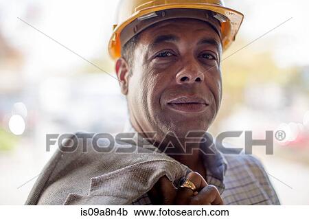 Stock Image - Close up portrait of mature man wearing hard hat. Fotosearch
