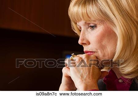 Stock Image - Close up portrait of mature woman looking pensive. Fotosearch