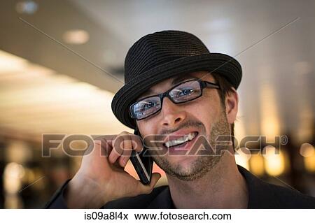 Stock Photo - Close up portrait of mid adult male on mobile phone. Fotosearch