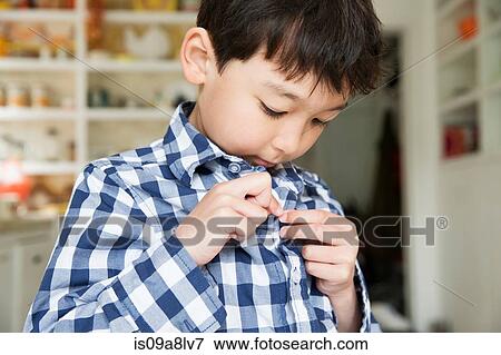 Close up portrait of young boy fastening shirt buttons View Large Photo Image Stock Photo - Close up portrait of young boy fastening shirt buttons. Fotosearch