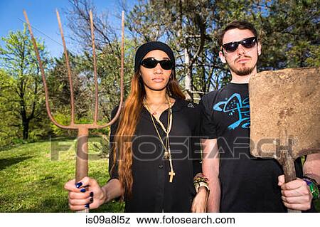Couple holding pitchfork and spade, portrait View Large Photo Image Stock Photo - Couple holding pitchfork and spade, portrait. Fotosearch