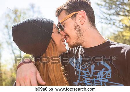 Stock Photograph - Couple kissing, woman wearing knit hat. Fotosearch