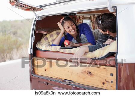 Couple lying together in the back of camper van, smiling View Large Photo Image Picture - Couple lying together in the back of camper van, smiling. Fotosearch