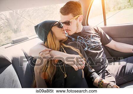 Stock Photograph - Couple on backseat in car, kissing. Fotosearch