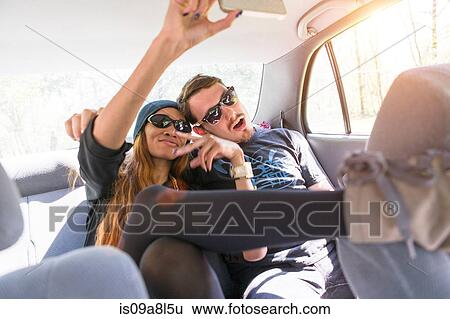 Couple on backseat in car photographing themselves View Large Photo Image Stock Photograph - Couple on backseat in car photographing themselves. Fotosearch