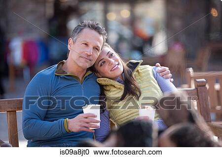 Couple sitting and enjoying warm drinks outside View Large Photo Image Stock Image - Couple sitting and enjoying warm drinks outside. Fotosearch