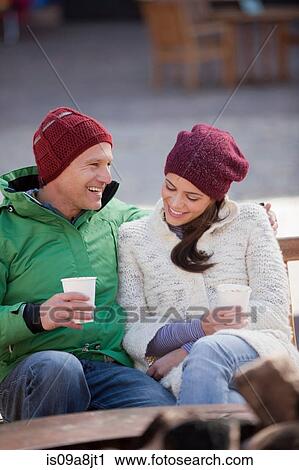 Couple sitting and enjoying warm drinks outside View Large Photo Image Stock Image - Couple sitting and enjoying warm drinks outside. Fotosearch