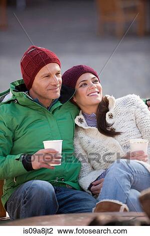 Couple sitting and enjoying warm drinks outside View Large Photo Image Stock Image - Couple sitting and enjoying warm drinks outside. Fotosearch