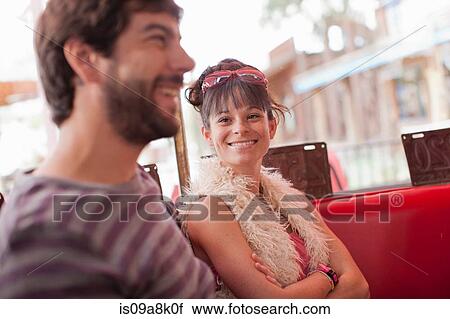 Stock Image - Couple sitting together in diner, smiling. Fotosearch