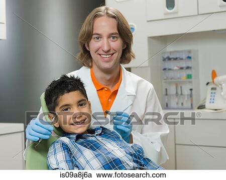 Dentist and young boy smiling, portrait View Large Photo Image Stock Image - Dentist and young boy smiling, portrait. Fotosearch