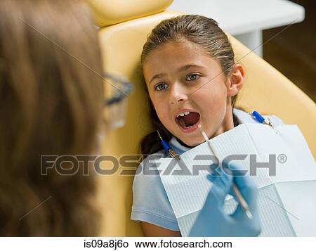 Dentist examining young patient's teeth View Large Photo Image Picture - Dentist examining young patient's teeth. Fotosearch