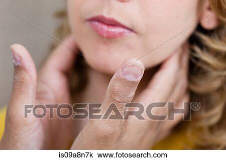 Stock Image - Doctor examining mid adult woman's throat, close up. Fotosearch