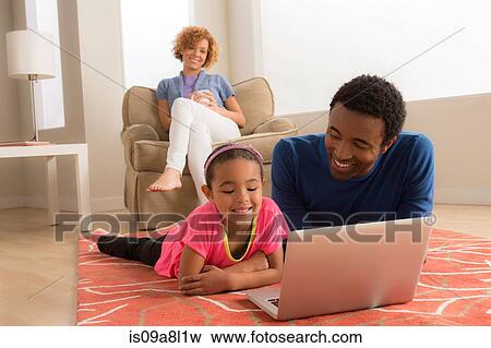 Father and daughter on floor using laptop View Large Photo Image Stock Photo - Father and daughter on floor using laptop. Fotosearch