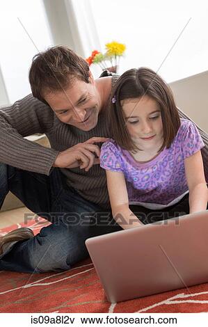 Stock Photo - Father and daughter using laptop. Fotosearch