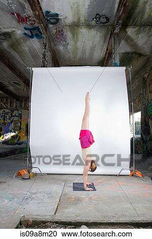 Female acrobat practicing handstand in old industrial interior View Large Photo Image Stock Image - Female acrobat practicing handstand in old industrial interior. Fotosearch